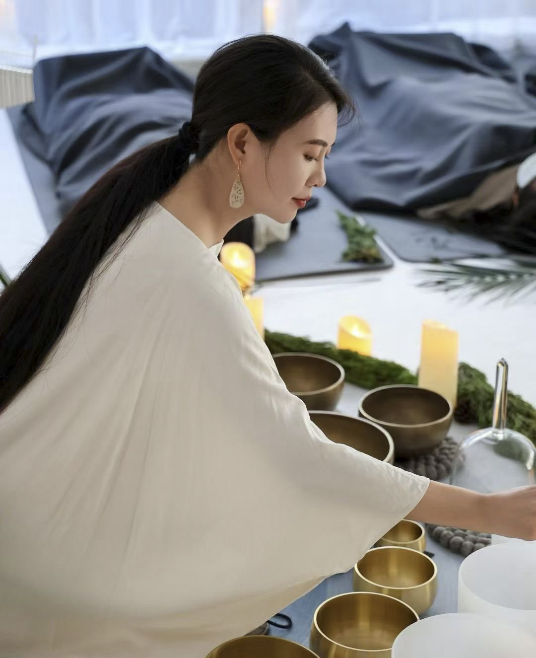 Sound bath facilitator with singing bowls.