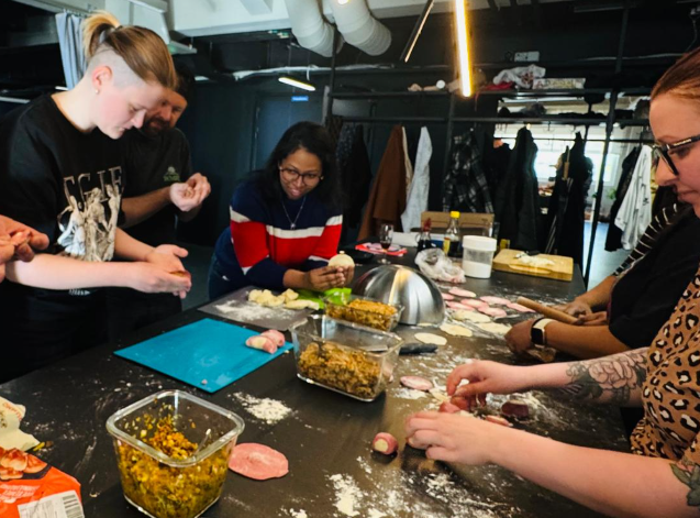 Participants making dumplings together during a shared workshop